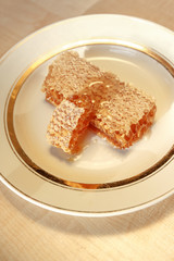 stacks of honey comb on a plate on wooden table