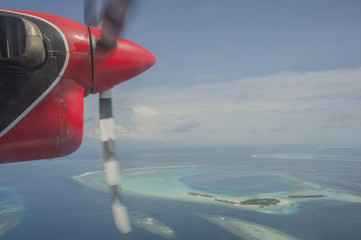 Naklejka na ściany i meble Sea view from the window when Seaplane Flying over beautiful resort in Indian ocean with skyline ,Maldives island. 