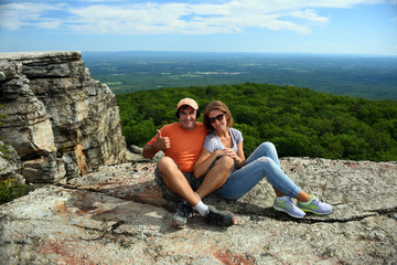 Naklejka na ściany i meble Couple sitting on the rock at Minnewaska State Park Reserve Upstate NY during summer time