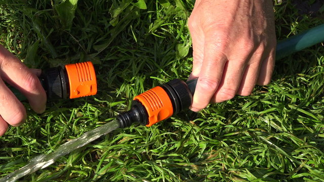 Man connecting watering hose in garden, 4K