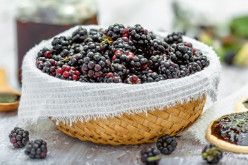 Basket of blackberries and bread with jam on table