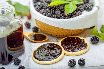 Fototapeta na wymiar Biscuits with blackberry jam on table