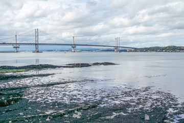Forth road bridge with construction site of the new forth bridge in background