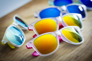 Many colorful fashion sunglasses close up on a shop