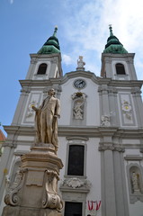 Obraz premium The Baroque Church of Mariahilf and statue of musician Franz Joseph Haydn in Vienna, Austria