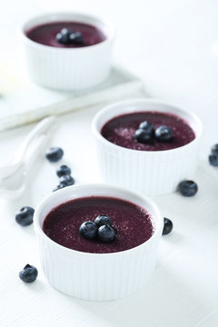 Delicious blueberry mousse in bowls on wooden table