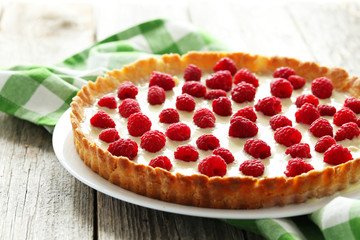 Sweet tart cake with raspberries on grey wooden background