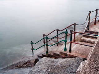 Old steps down to the sea. Long exposure, rusty railings.