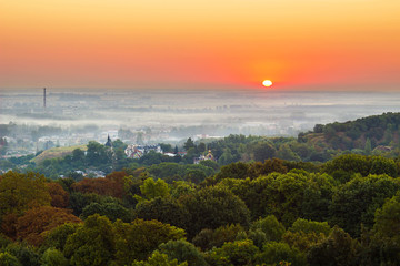 Obrazy na Szkle  Ekscytujący wschód słońca nad zamglonym miastem i parkiem, widok z lotu ptaka, Lwów