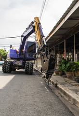 industrial backhoe, bulldozer moving drilling for road construction updates.