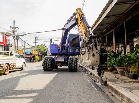 industrial backhoe, bulldozer moving drilling for road construction updates.