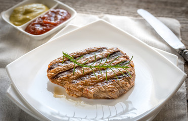 Beef steaks on the white square plate