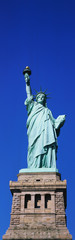 Obraz premium This is the Statue of Liberty on its full pedestal against a blue sky.