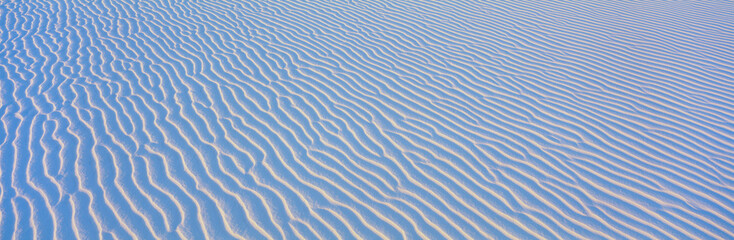 These are white sand dunes in morning light. There are line patterns in the sand from the wind. © spiritofamerica