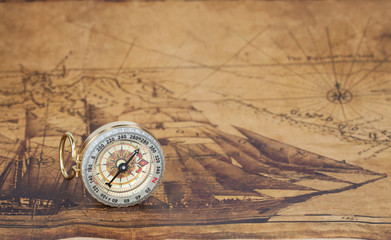 Vintage compass lies on an ancient map