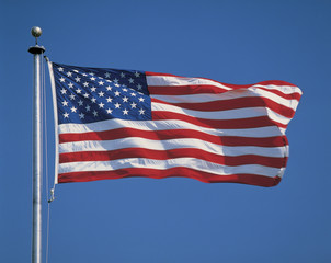 This is an American flag on a flagpole, waving in the wind.