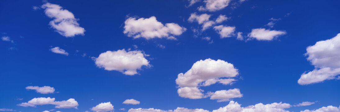 This is an image of a blue sky with white puffy clouds scattered throughout.
