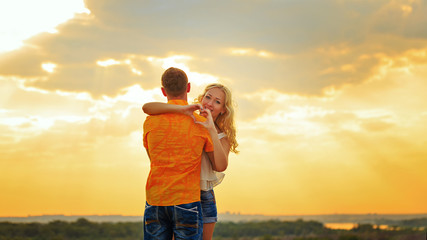 Loving couple hugging at sunset.