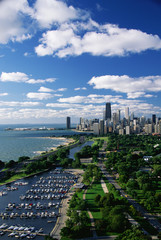 Obraz premium This shows Lincoln Park, Diversey Harbor, and Lake Michigan looking south toward the skyline. It has morning light in summertime. There are boats moored in the harbor next to the lake.