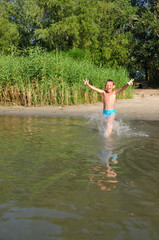The boy runs into the river