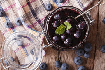 homemade blueberry jam in a glass jar close up. horizontal top view
