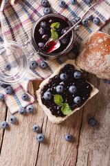 homemade blueberry jam and sweet bun close-up. Vertical top view
