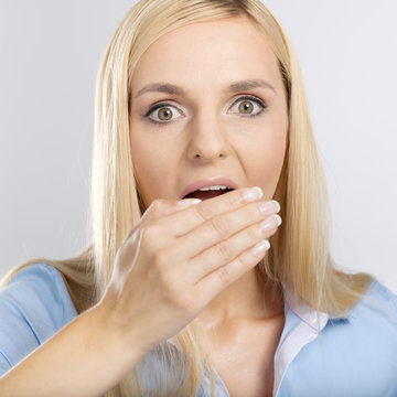 woman with hand over mouth