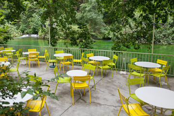 Empty tables on terrace at river bank in France