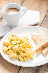 breakfast with scrambled egg, toasts and coffee.