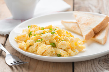 breakfast with scrambled egg, toasts and coffee.