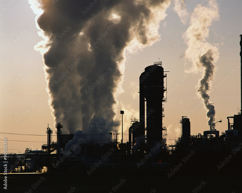 Wall mural this is an image of an industrial plant pushing billowing stacks of smoke into the sky. it is a petr