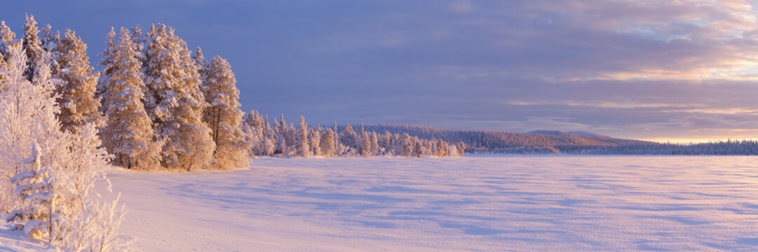 Frozen Äijäjärvi lake in Finnish Lapland in winter at sunset