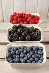 Raspberries, blueberries and blackberries in carton boxes