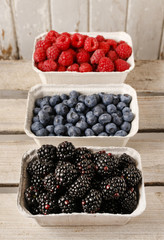 Raspberries, blueberries and blackberries in carton boxes