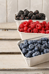 Raspberries, blueberries and blackberries in carton boxes