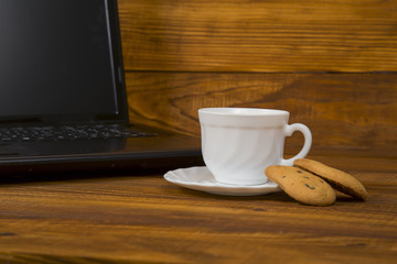 computer a cup of coffee and cookies