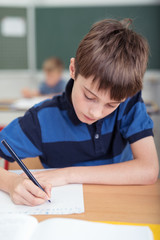 Naklejka premium junge schreibt in der schule