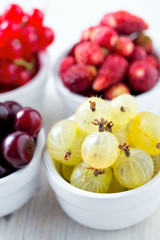 summer berries in a bowl on wooden surface