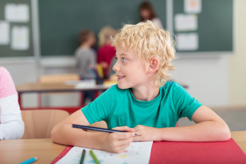 schulkind sitzt am tisch und schaut zur seite © contrastwerkstatt