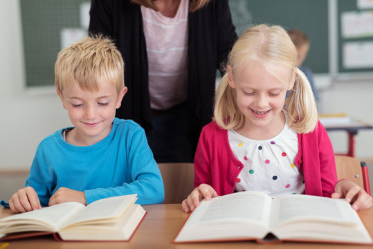 zwei kleine kinder lesen im unterricht