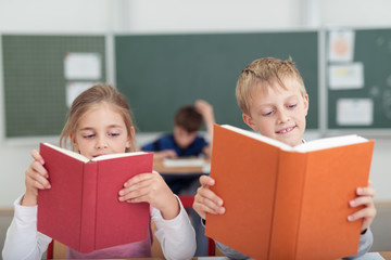 lächelnde kinder mit büchern im klassenzimmer