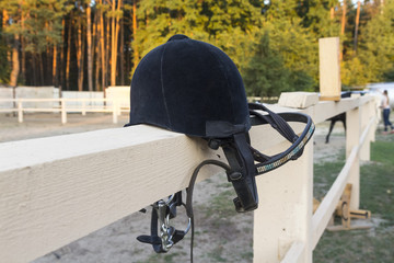 Helmet for the rider's horse. Lying on the fence