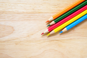 Fototapeta premium Color pencils on wood background