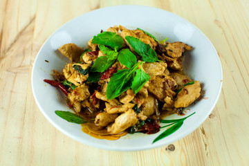 Spicy Thai basil chicken ready to eat on traditional plate