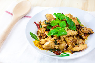 Spicy Thai basil chicken ready to eat on traditional plate. (Shallow aperture intended for  the aesthetic quality of the blur.)