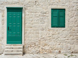 Wooden door and window with closed wooden shutters