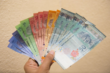 hand holding with Malaysian money banknotes