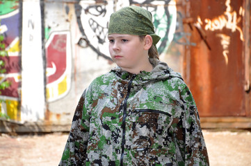 boy teenager in a camouflage and with equipment for paintball