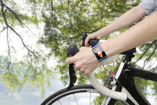 Biking woman hands wearing health sensor smart watch