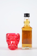 red skull and whiskey on white table